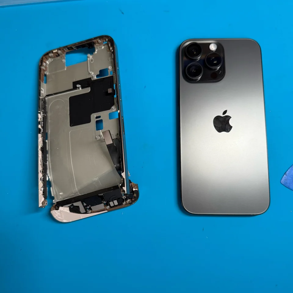 Removed damaged iPhone housing beside the assembled phone, rear view