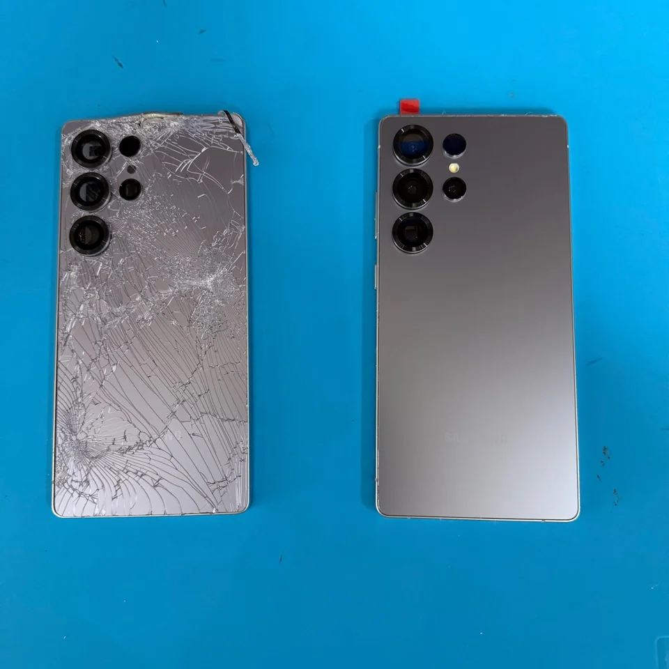Shattered Samsung rear cover beside the phone with an intact replacement back