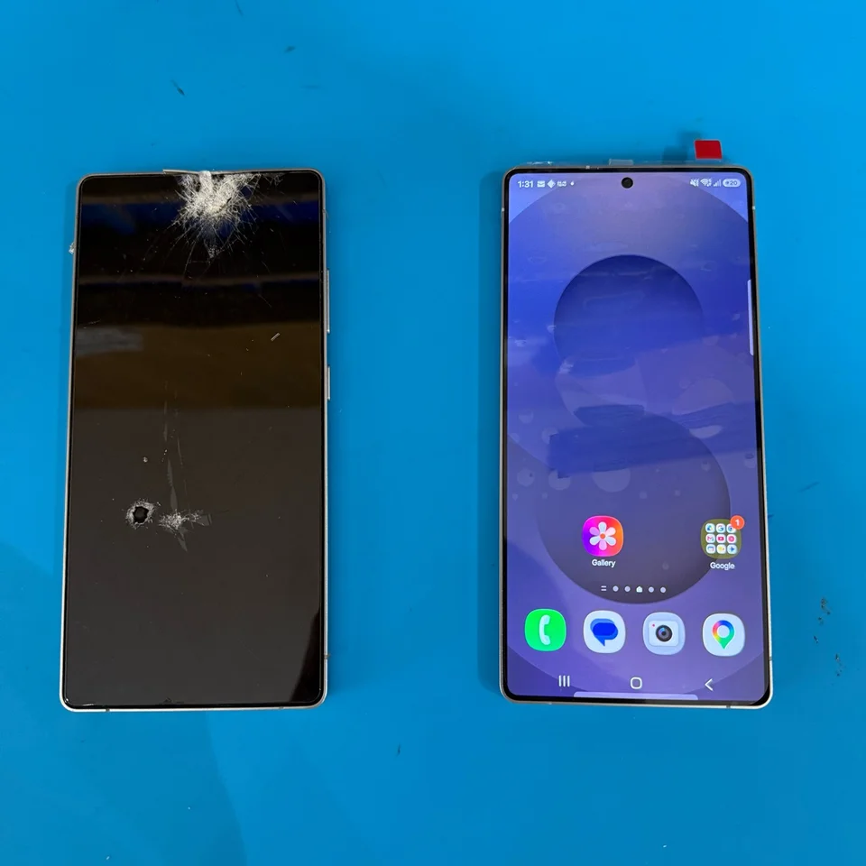 Cracked Samsung display beside the phone with its replacement screen working